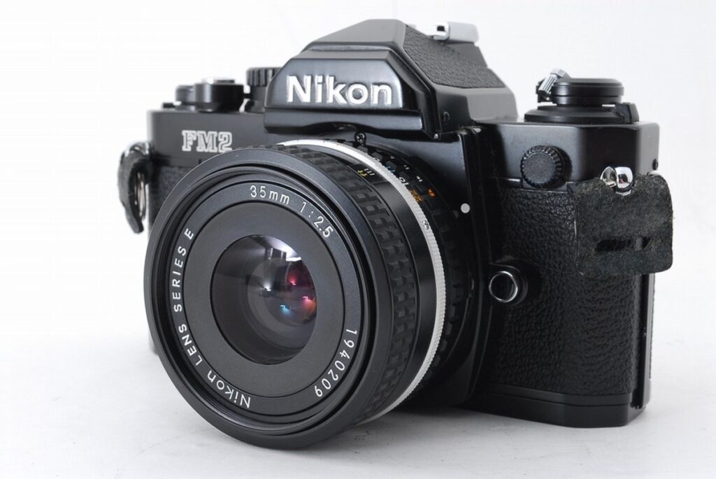 Nikon FM2 ブラックボディと35mm F2.5 Series Eレンズ付きのフィルム一眼レフカメラ写真
