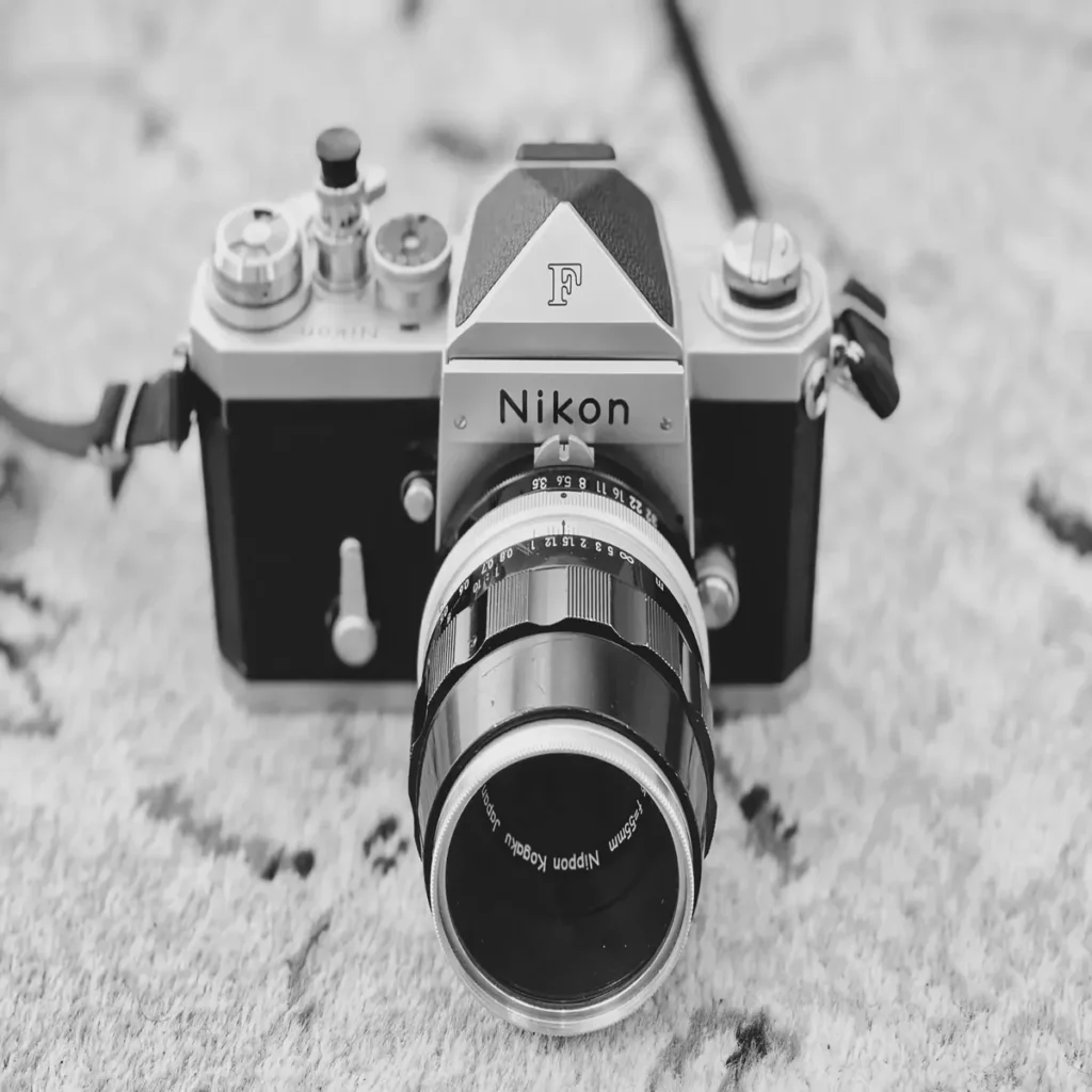 alt="Nikon F クロームボディのフィルム一眼レフカメラ。クラシックなデザインと標準レンズ"
