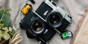 PENTAX SPOTMATICとSuper-Takumarレンズのフィルムカメラ2台と35mmフィルム。ペンタックスのフィルムカメラ買取イメージ